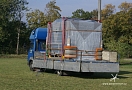 Vzduchotechnická jednotka připravená na korbě nákladního auta k vzdušnému transportu. Protože se bude zasouvat otvorem do budovy jsou na rozích matrace k ztlumení případného kontaktu se stěnou.  
